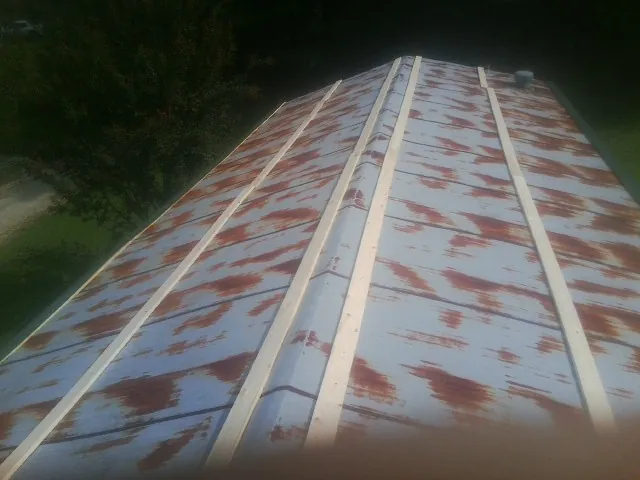 Rusted metal roof panels with new wood purlins before replacement — Storm Damage Roof Repair in Iuka by Roofing Brothers